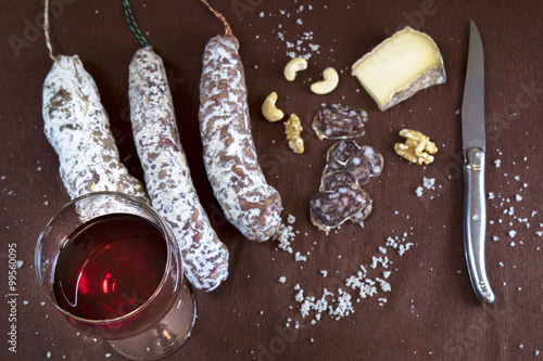 Aperitif with red wine, saucisson, cheese and nuts