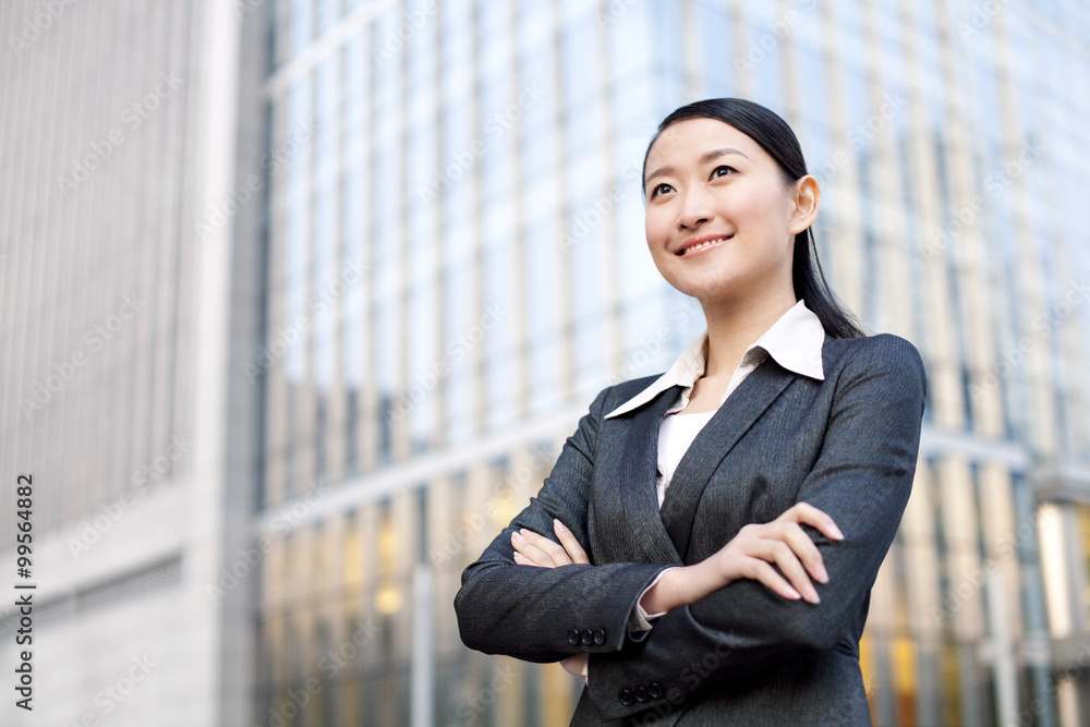 A businesswoman outside office buildings contemplating A businesswoman outside office buildings contemplating