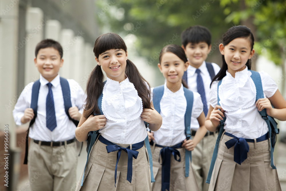 Lovely schoolchildren in uniform on the way to school Lovely schoolchildren in uniform on the way to school