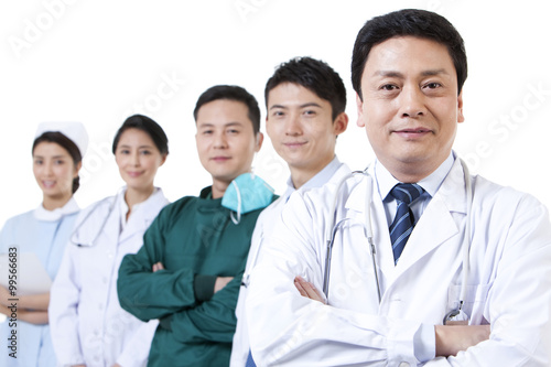 Portrait of mature male doctor with medical team in background