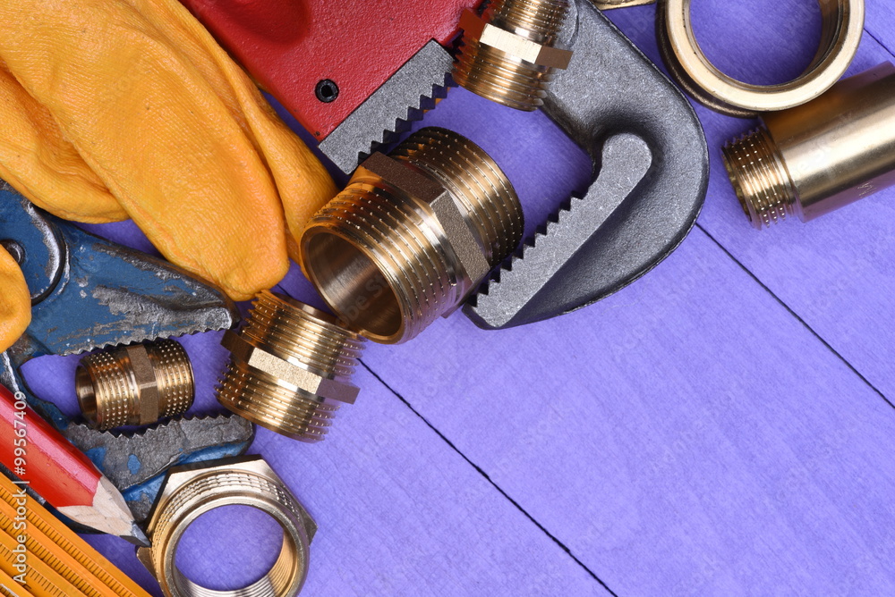 Tools and plumbing accessories on a wooden background