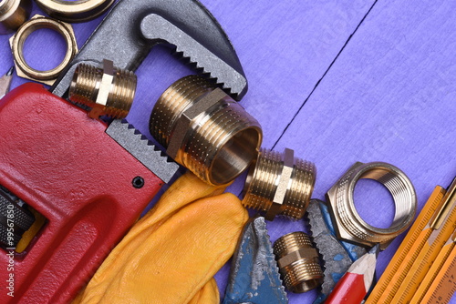 Tools and plumbing accessories on a wooden background