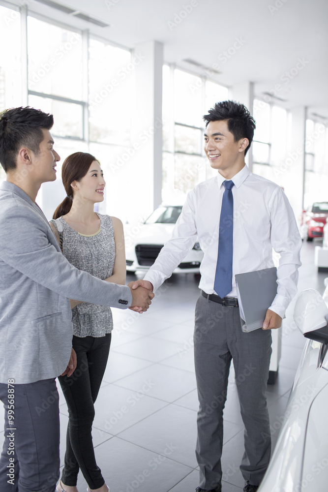 Young couple buying car in showroom Young couple buying car in showroom