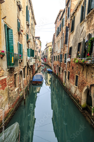 Picturesque view of Gondolas on lateral narrow Canal on a foggy day, Venice, Italy.