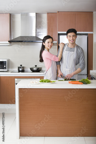 Happy young couple preparing meal