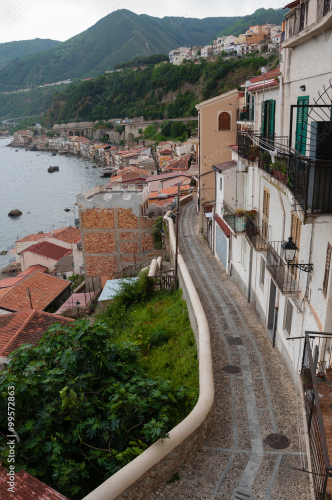 Narrow street and stairs next to cute italian houses in old town of Scilla fronting the ocean