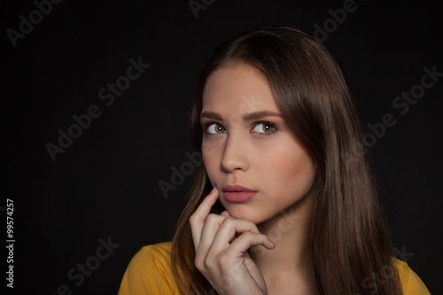Contemplative thinking woman student at a black background - Stock Image