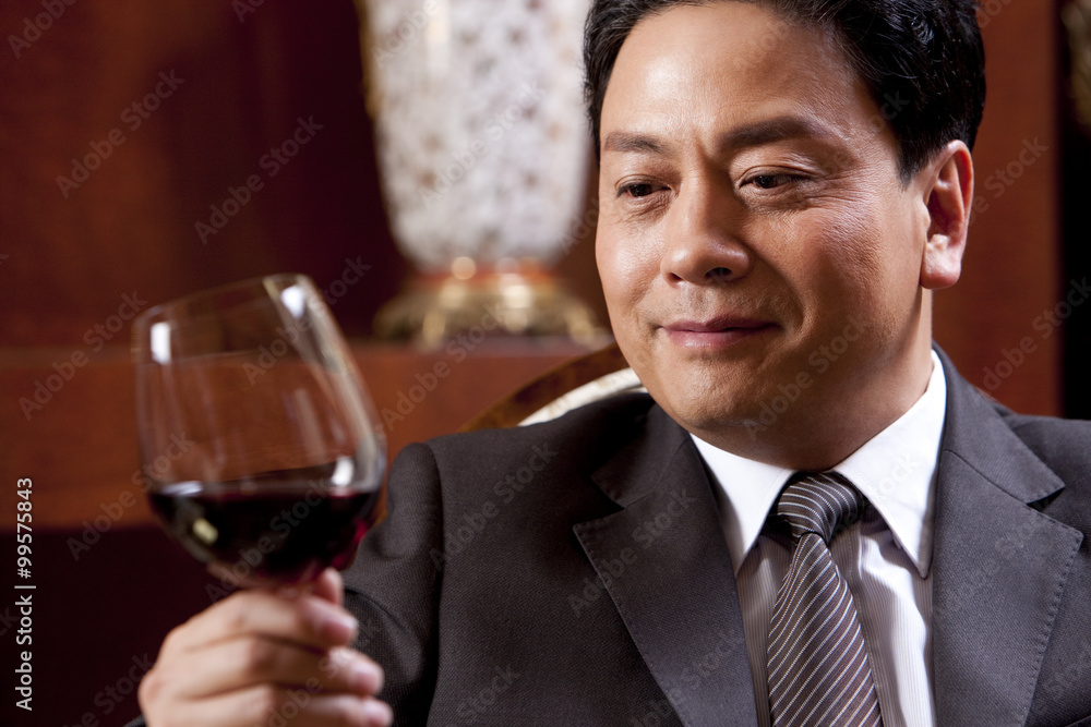 Mature businessman enjoying wine in a luxurious room Mature businessman enjoying wine in a luxurious room