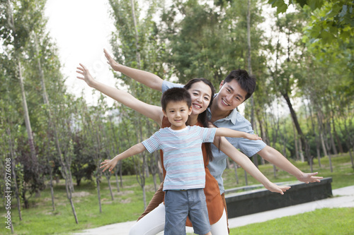 Portrait of happy young family with arms outstretched