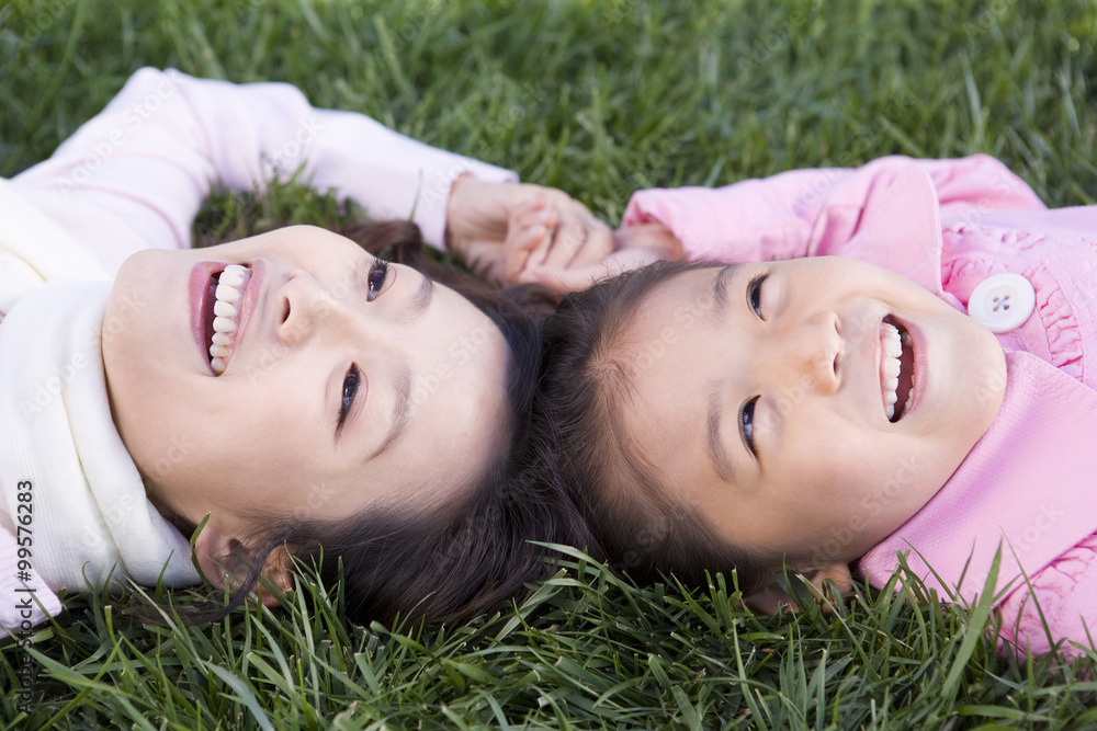 A mother and daughter lie in the grass A mother and daughter lie in the grass