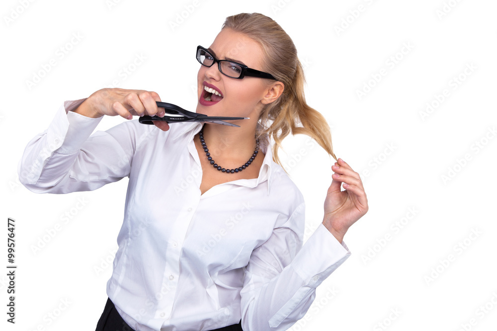 Angry businesswoman cutting her hair with scissors at office - Stock Image Angry businesswoman cutting her hair with scissors at office - Stock Image