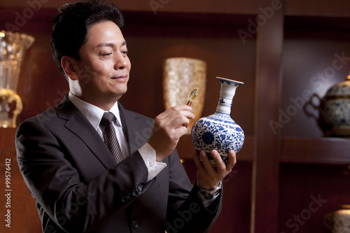 Fotografia Mature businessman admiring an antique Chinese vase