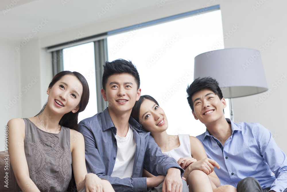 Fototapeta premium Happy young friends sitting on the sofa