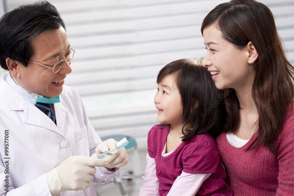 Dentist teaching the right way of brushing teeth Dentist teaching the right way of brushing teeth