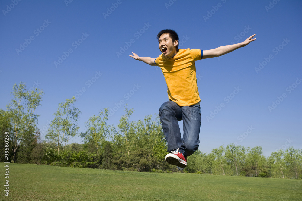 Young man jumping in air at park Young man jumping in air at park