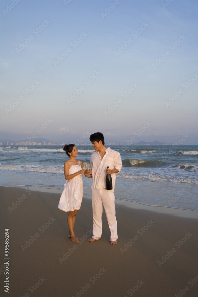 Young couple celebrating with a bottle of champagne Young couple celebrating with a bottle of champagne