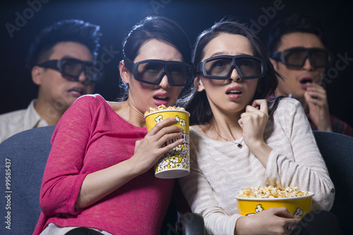 Young women watching 3D movie in cinema