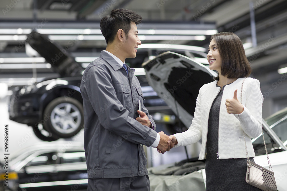 Auto mechanic and car owner shaking hands Auto mechanic and car owner shaking hands