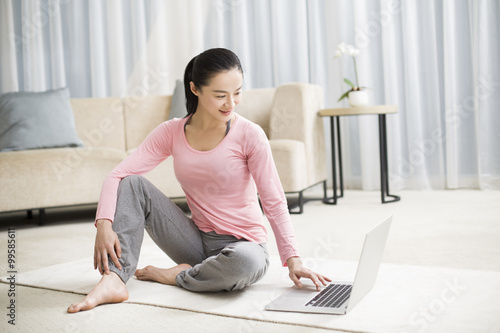 Young woman using laptop in living room