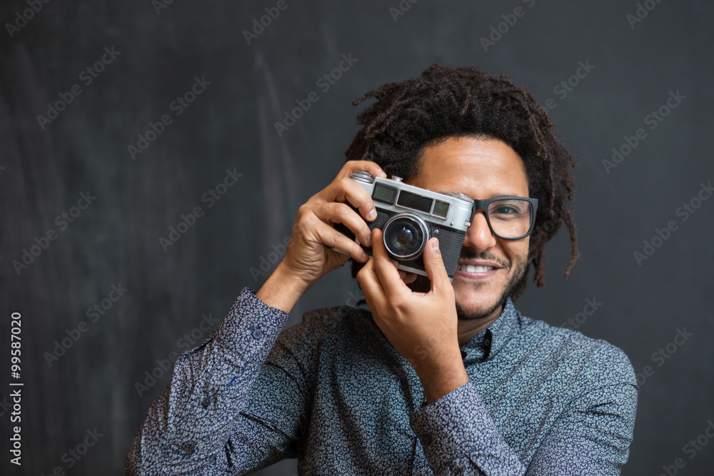 Portrait of a smiling afro american man making photo on retro ca Portrait of a smiling afro american man making photo on retro ca