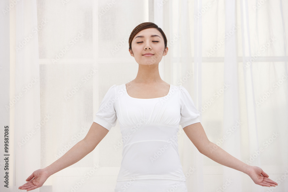 Young woman meditating with her eyes closed Young woman meditating with her eyes closed