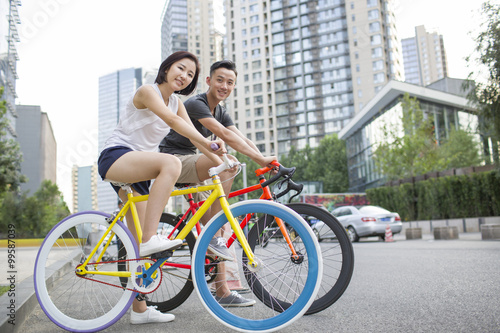 Fototapeta Naklejka Na Ścianę i Meble -  Happy young couple riding bicycles