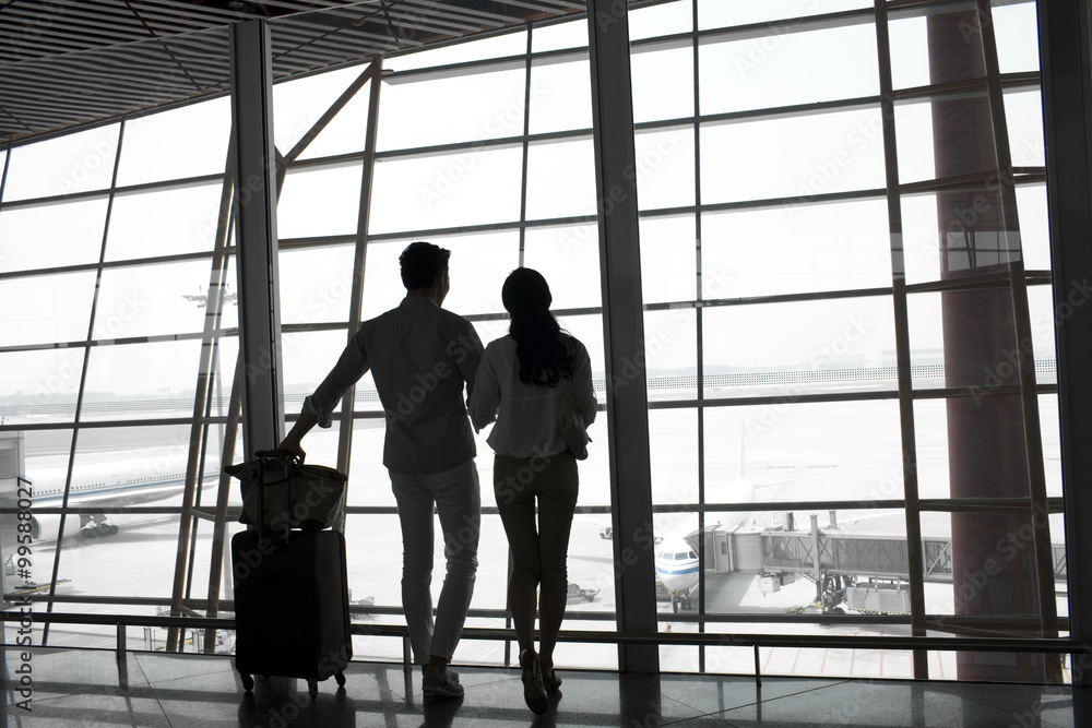 Young couple at the airport looking at view