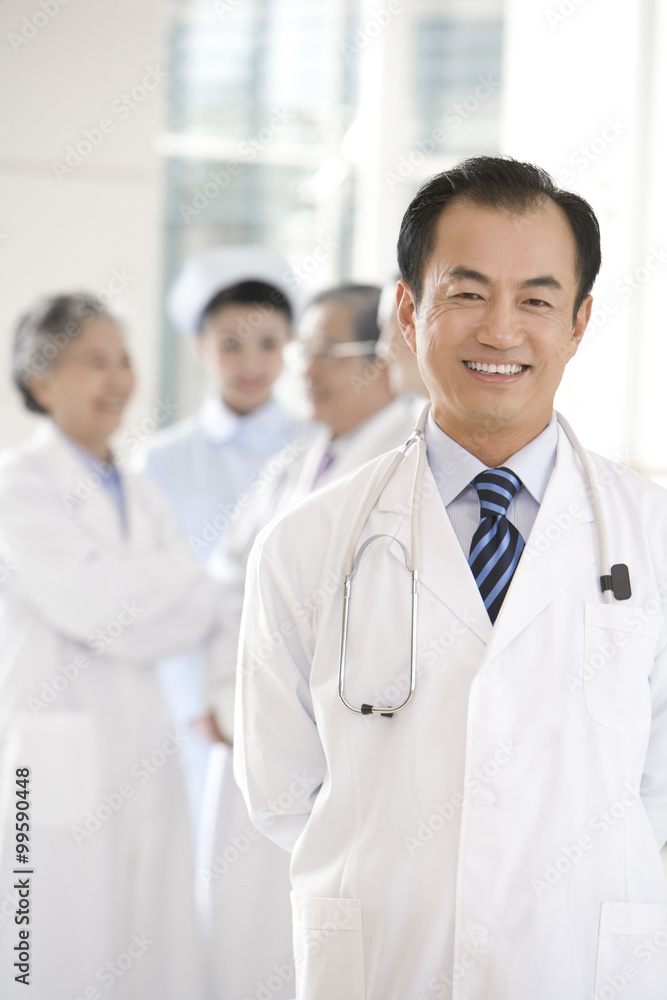 Doctor in Foreground with Doctors and Nurse in Background Doctor in Foreground with Doctors and Nurse in Background