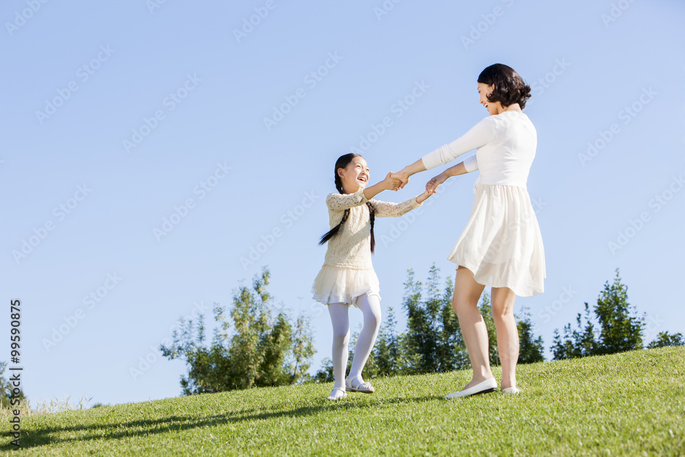 Young mother and daughter playing on the lawn Young mother and daughter playing on the lawn