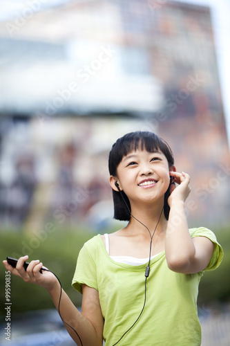 Happy schoolgirl listening to MP3 player