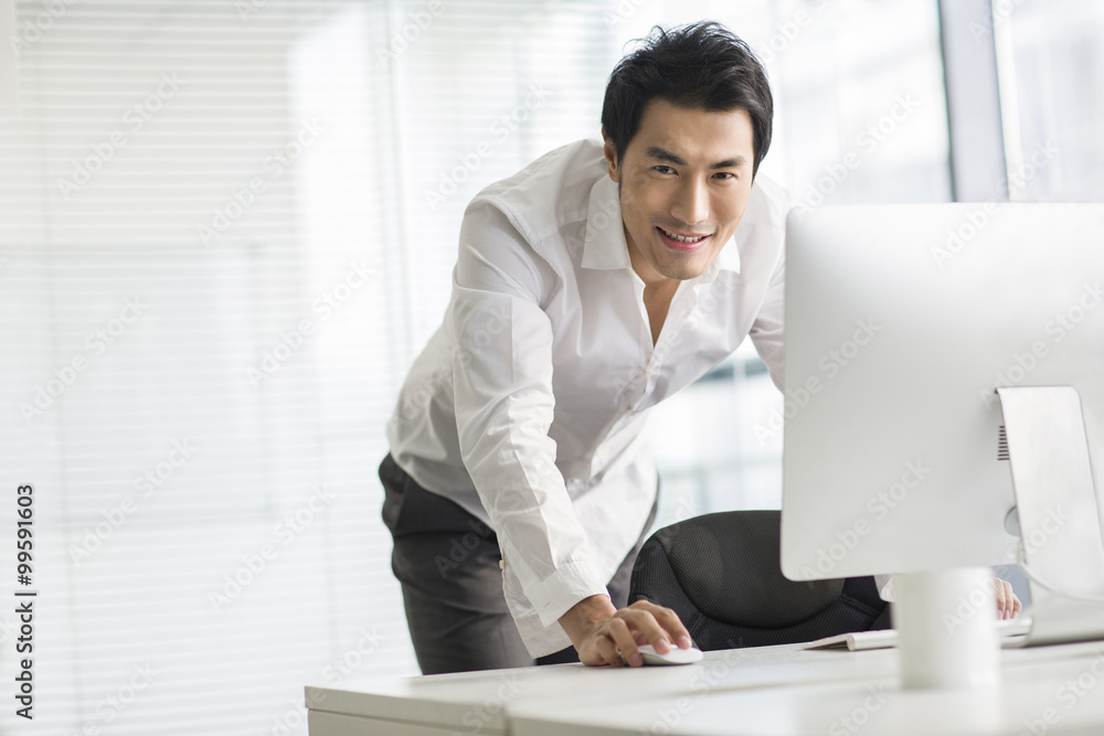 Young businessman using computer in office Young businessman using computer in office