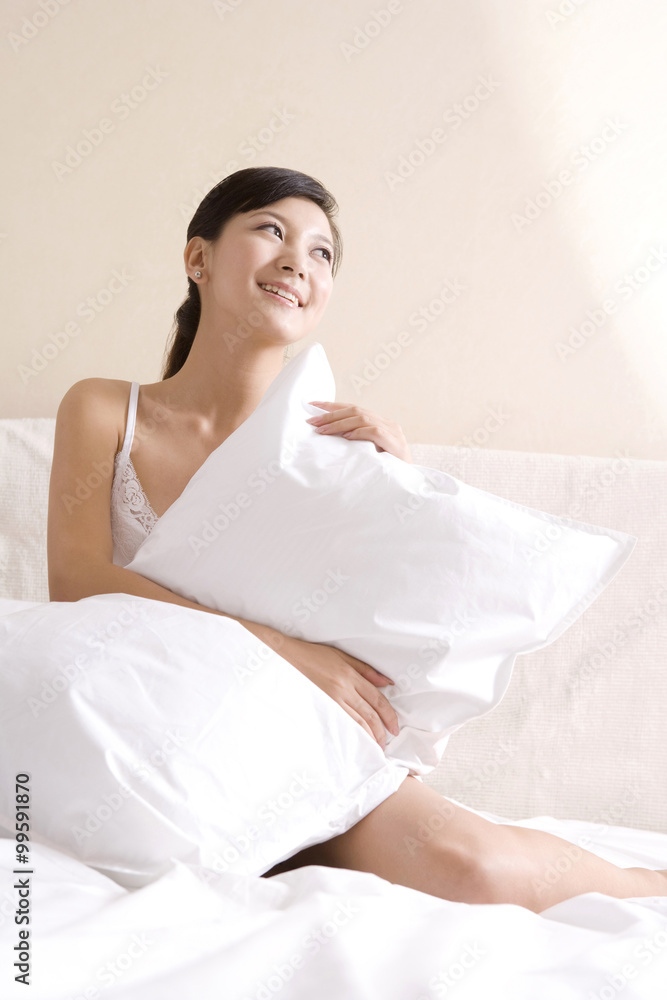 Asian woman on bed with a pillow Asian woman on bed with a pillow