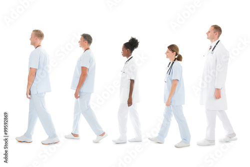 Side View Of Medical Team Walking In Row