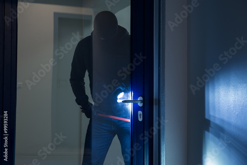 Schilderij op canvas Burglar Using Crowbar To Open Glass Door