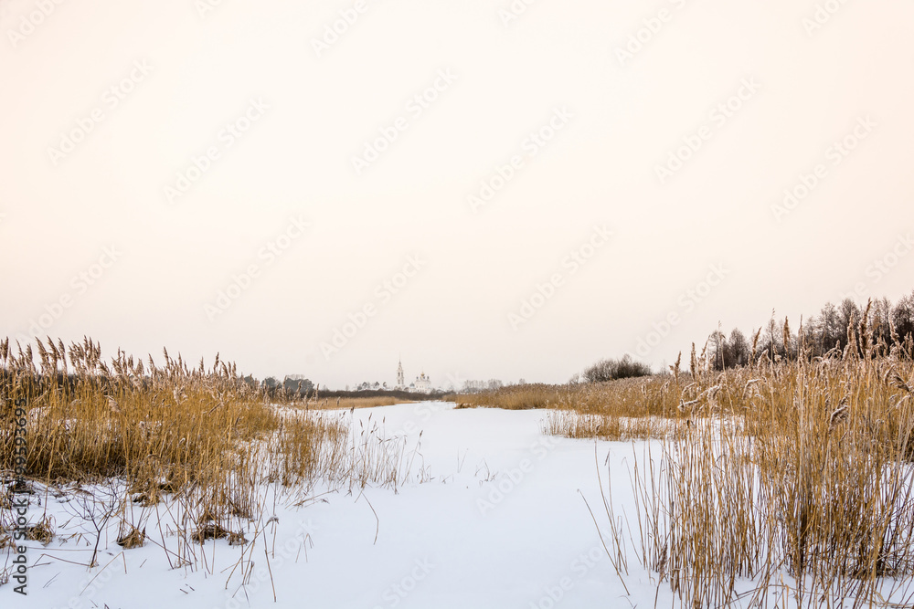 View of the Nikolo-Tikhonov monastery Luh with frozen river Luh. View of the Nikolo-Tikhonov monastery Luh with frozen river Luh.