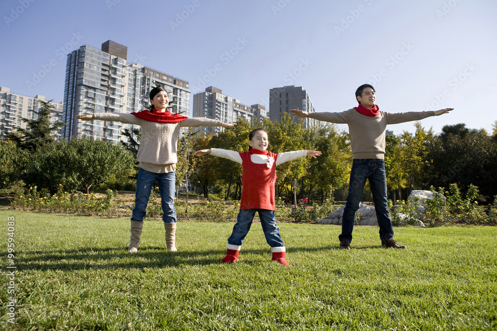 Fototapeta premium Young Family Playing in a Park in Autumn