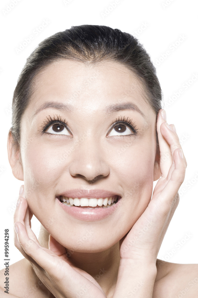 Beauty shot of a young woman touching her face Beauty shot of a young woman touching her face
