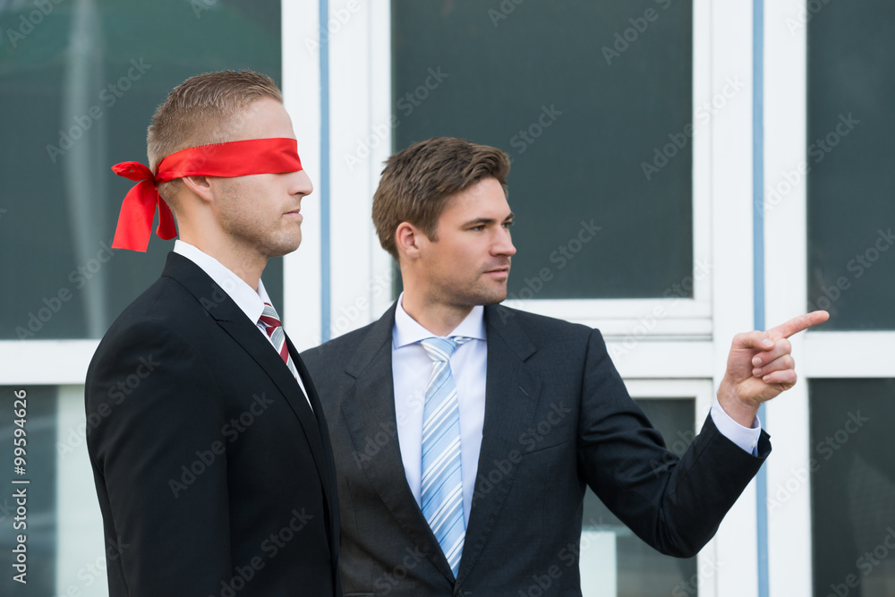 Businessman Assisting Blindfolded Partner Businessman Assisting Blindfolded Partner