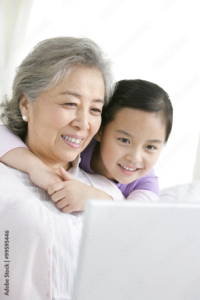 Chinese grandmother with grandaughter using a laptop Chinese grandmother with grandaughter using a laptop