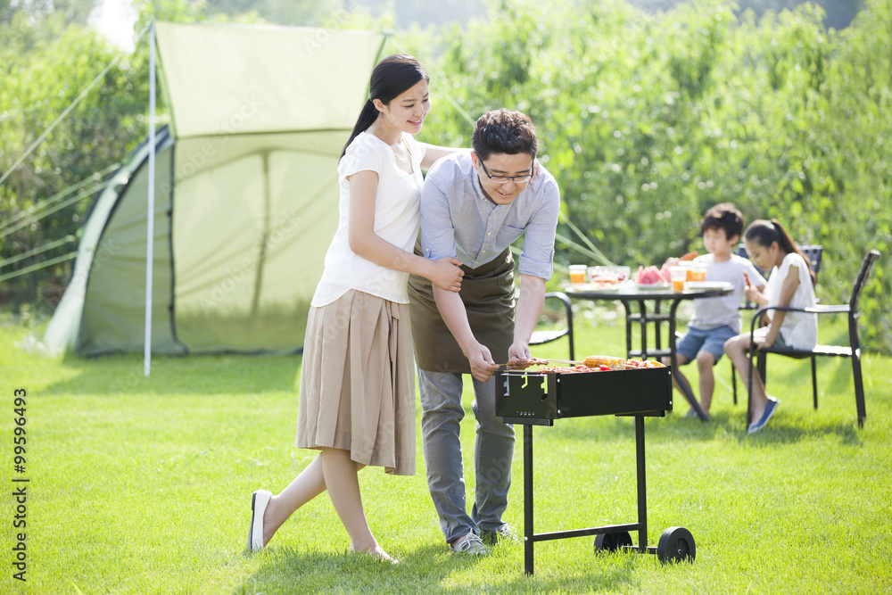 Young family barbecuing outdoors Young family barbecuing outdoors