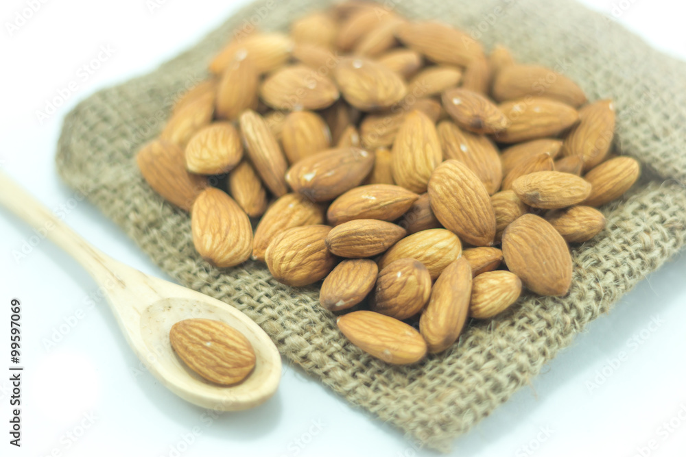 Obraz premium Almonds in sack isolated on white background