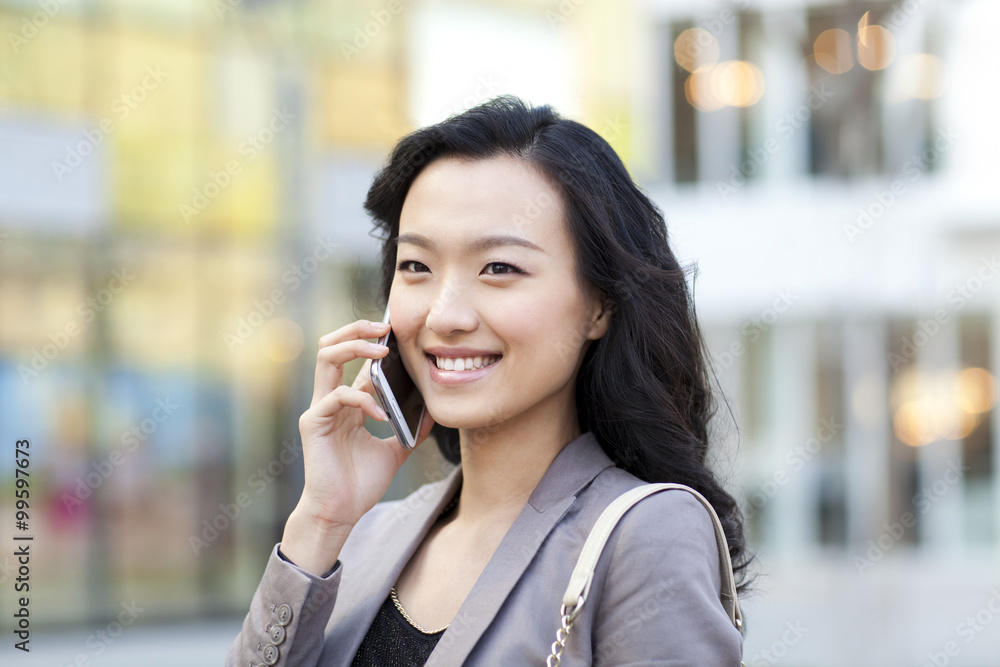 Cheerful young woman talking on the phone in city Cheerful young woman talking on the phone in city
