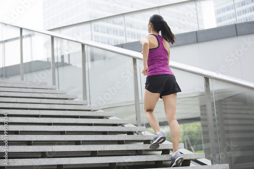 Young woman running up stairs for exercise