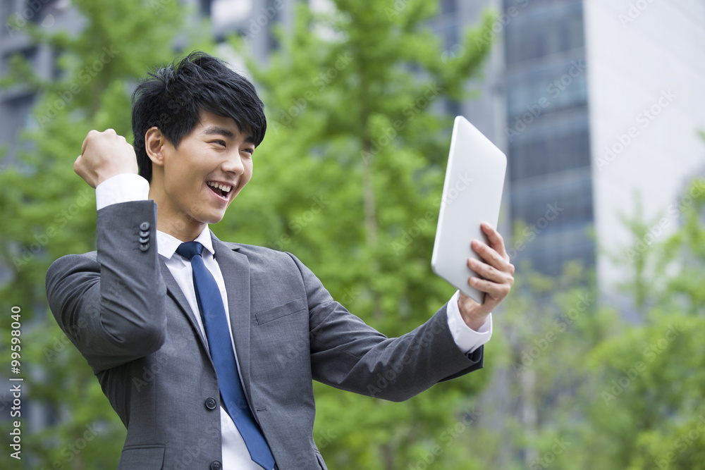 Excited young businessman using digital tablet Excited young businessman using digital tablet