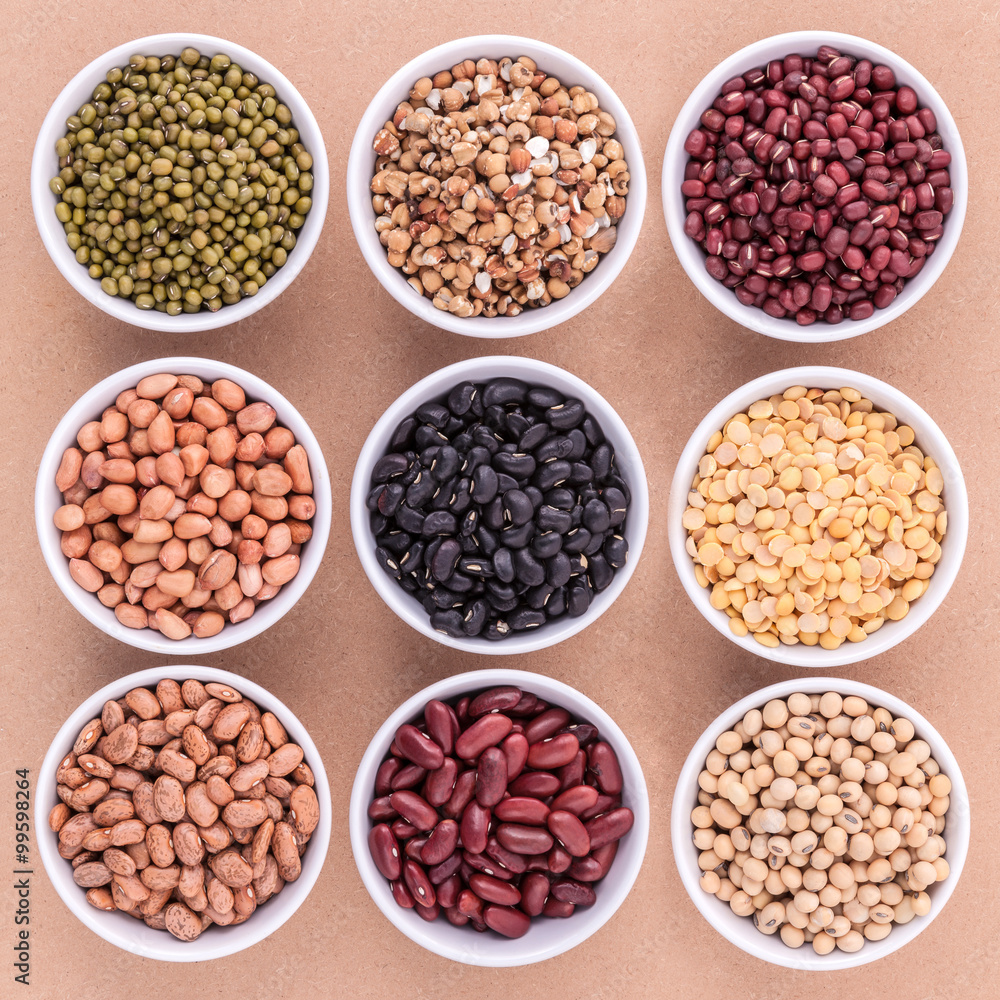 Mixed beans and lentils in the white bowl on brown background. Mixed beans and lentils in the white bowl on brown background.