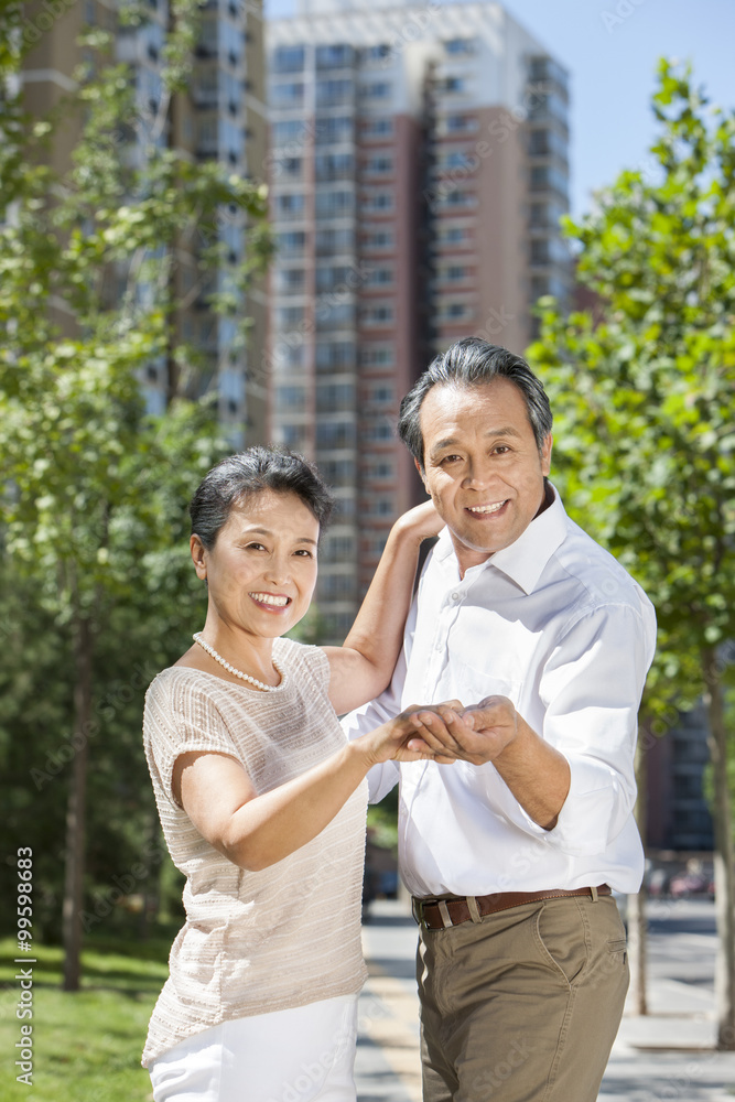 Cheerful mature couple dancing outdoors Cheerful mature couple dancing outdoors