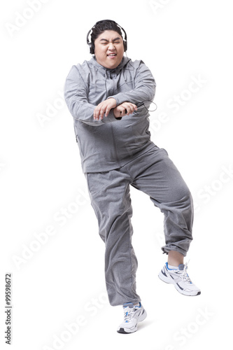 Fashionable Chubby man listening to music and dancing