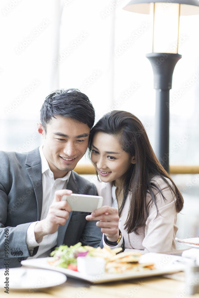 Young couple photographing in restaurant Young couple photographing in restaurant
