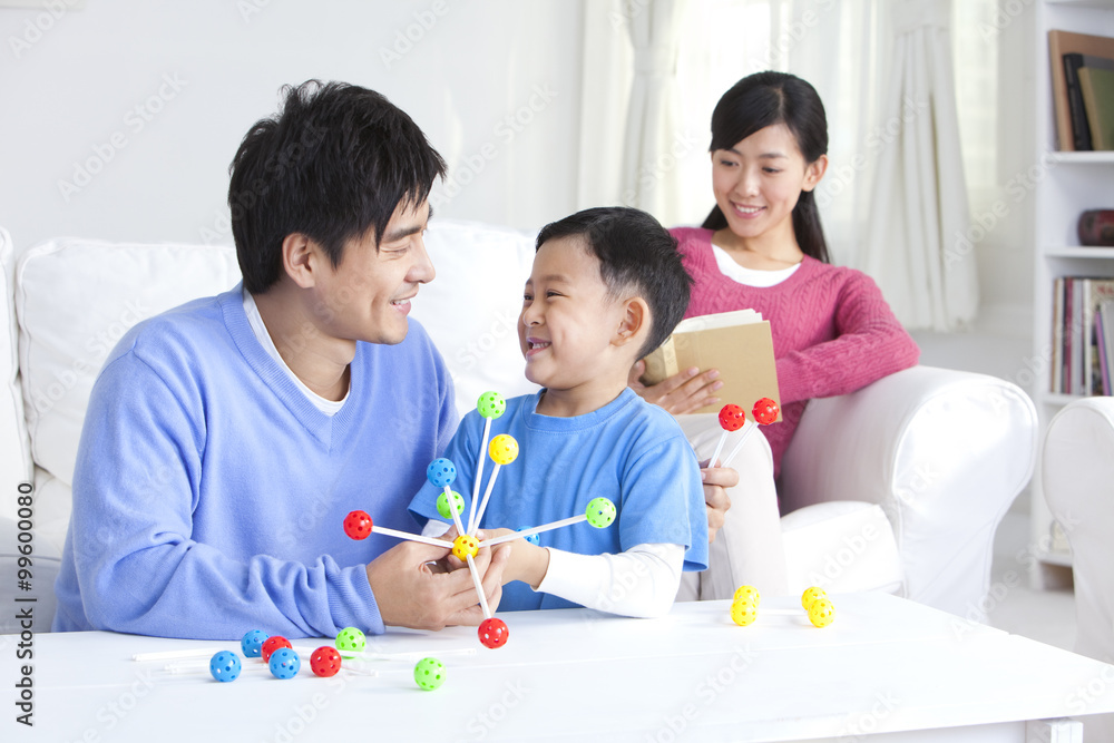 Young Chinese boy with parents and toys in the living room Young Chinese boy with parents and toys in the living room