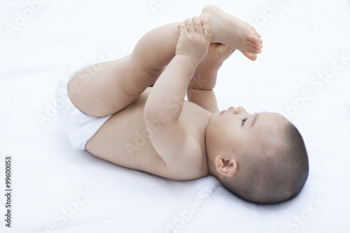 Cute Chinese baby boy playing in bed
